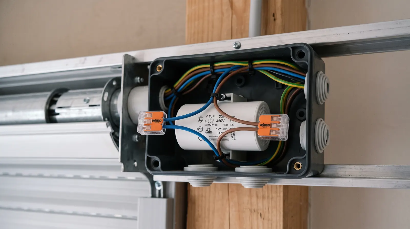 Condensateur neuf branché sur des bornes à levier dans une boîte de connexion